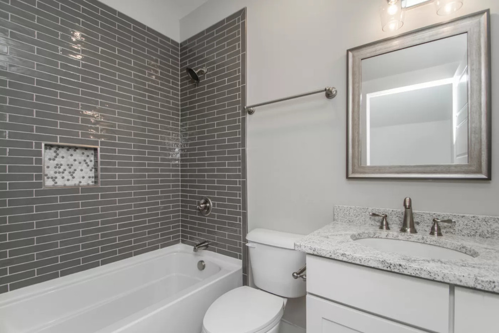 Exempel på ett litet klassiskt vit vitt badrum för barn, med skåp i shakerstil, vita skåp, ett badkar i en alkov, en dusch/badkar-kombination, en toalettstol med separat cisternkåpa, grå kakel, keramikplattor, grå väggar, klinkergolv i porslin, ett undermonterad handfat, granitbänkskiva, grått golv och dusch med duschdraperi