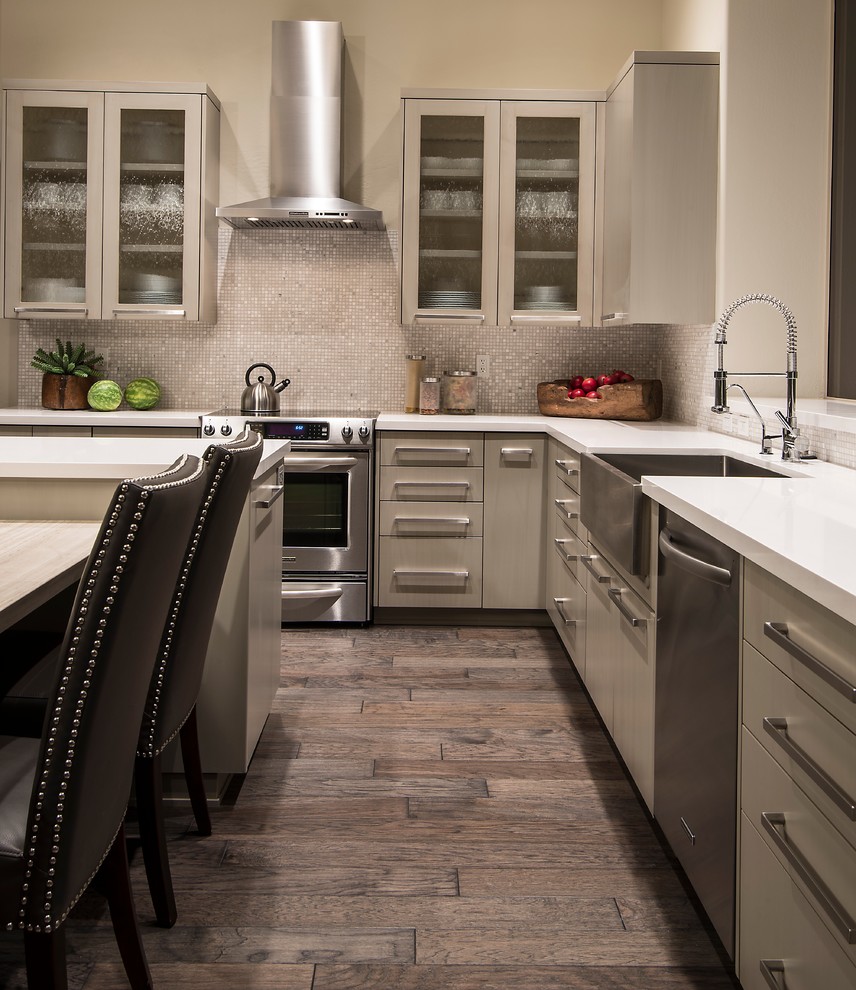 This is an example of a transitional eat-in kitchen in Phoenix with a farmhouse sink, flat-panel cabinets, beige cabinets, beige splashback, mosaic tile splashback and stainless steel appliances.