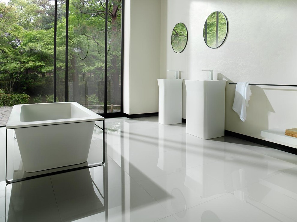 Modelo de cuarto de baño actual con bañera exenta y paredes blancas