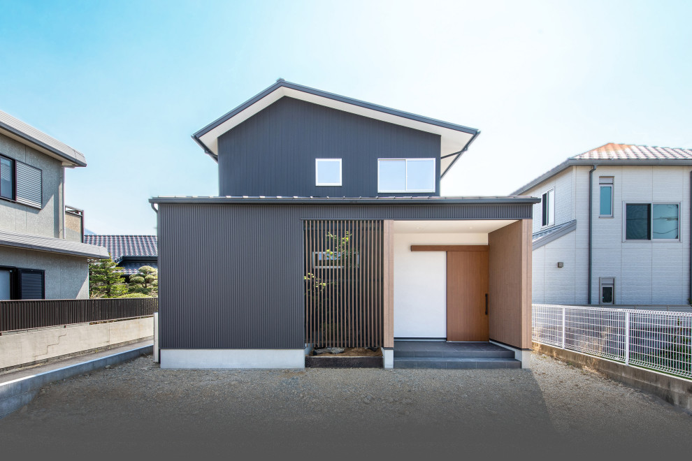 Design ideas for a mid-sized asian two-storey black house exterior in Other with a gable roof and a metal roof.
