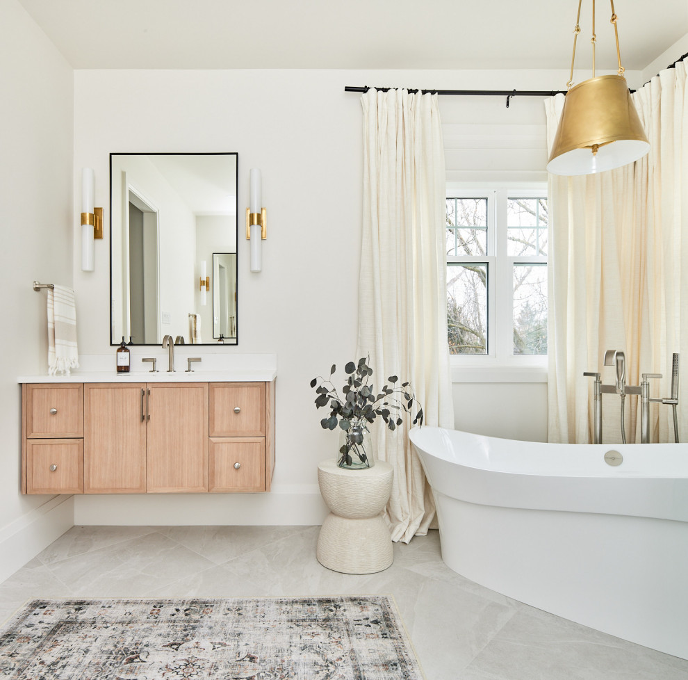 Mid-sized transitional porcelain tile, single-sink and gray floor freestanding bathtub photo with light wood cabinets, white walls, quartz countertops, white countertops, a floating vanity and recessed-panel cabinets