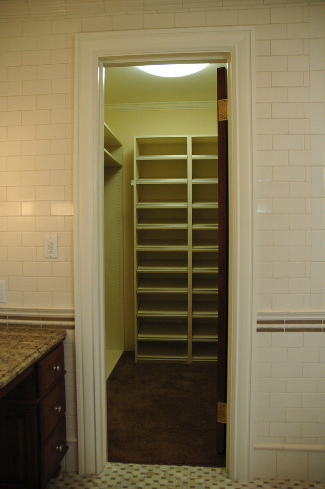 Midcentury gender-neutral walk-in wardrobe in Milwaukee with carpet.