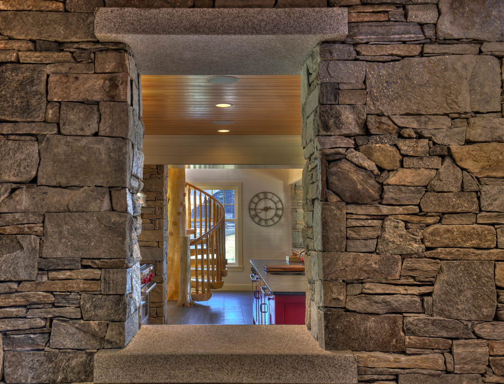 Example of a mountain style slate floor kitchen design in Burlington with a farmhouse sink, shaker cabinets, stainless steel appliances and an island