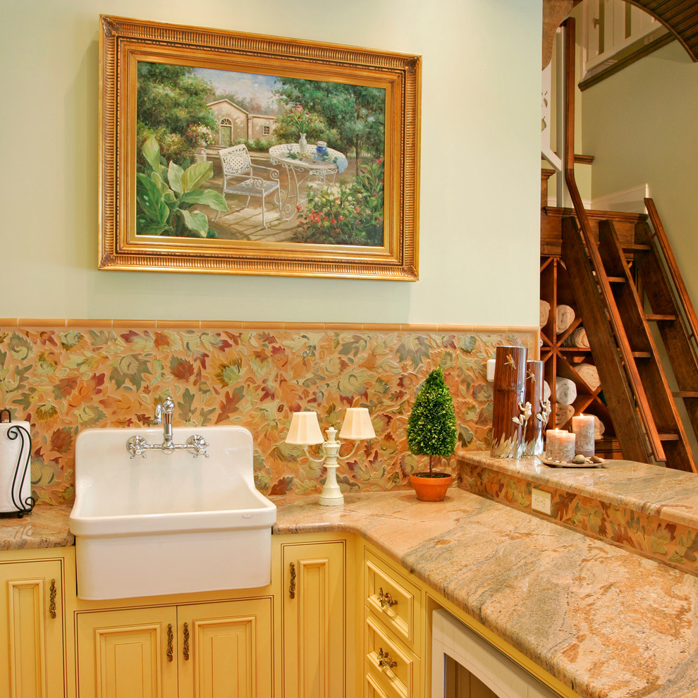 Photo of a country kitchen in Philadelphia with a farmhouse sink, recessed-panel cabinets, beige cabinets, granite benchtops, multi-coloured splashback, panelled appliances and terra-cotta floors.