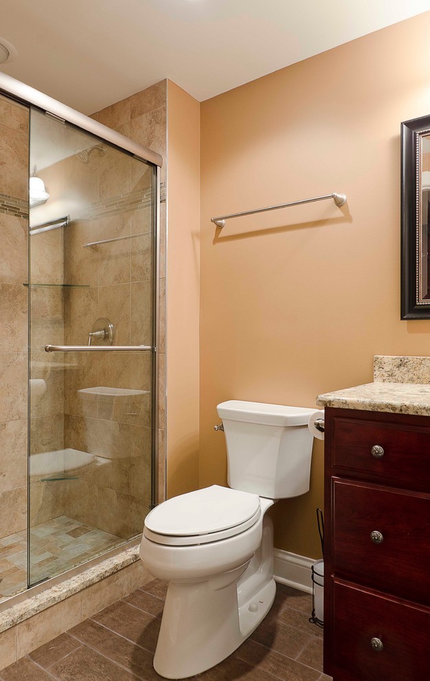Inspiration for a small traditional 3/4 bathroom in Chicago with an undermount sink, flat-panel cabinets, dark wood cabinets, granite benchtops, an alcove shower, a two-piece toilet, brown tile, porcelain tile, beige walls and porcelain floors.