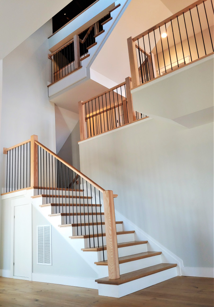Exemple d'un très grand escalier droit chic avec des marches en bois, des contremarches en bois et un garde-corps en matériaux mixtes.