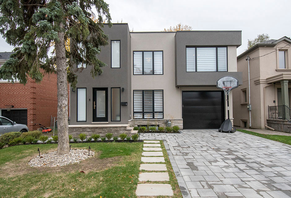 Mid-sized contemporary two-storey stucco house exterior in Toronto with a flat roof, a mixed roof, a black roof and board and batten siding.