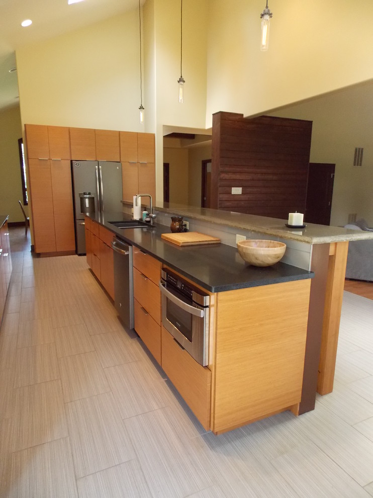 This is an example of a large contemporary galley eat-in kitchen in Baltimore with a farmhouse sink, flat-panel cabinets, light wood cabinets, concrete benchtops, metallic splashback, glass tile splashback, stainless steel appliances, cork floors and with island.