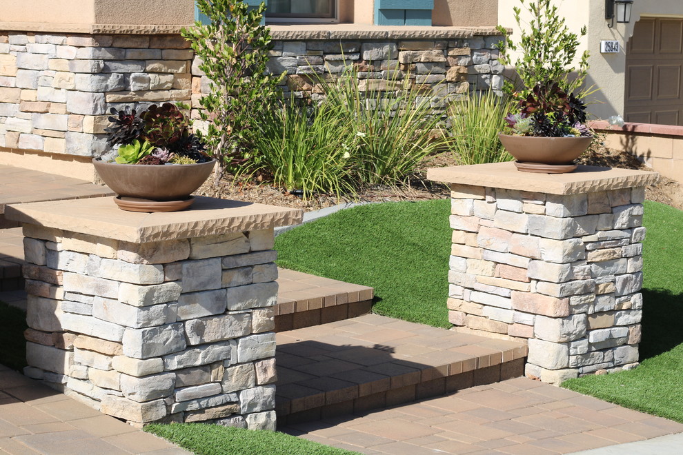 Inspiration for a country front yard garden in Orange County with concrete pavers.