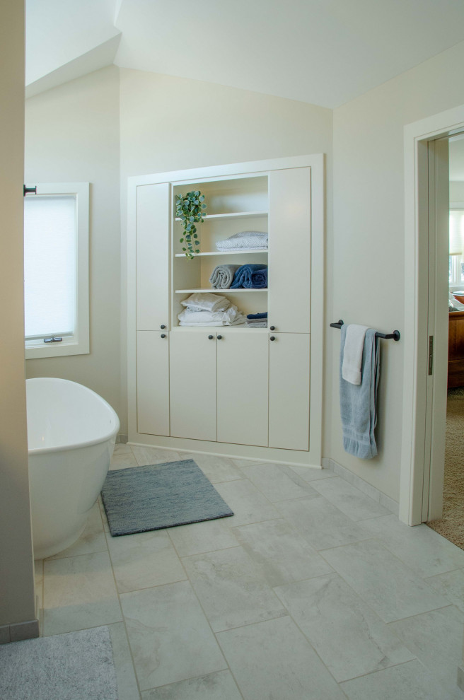 Modern inredning av ett stort beige beige en-suite badrum, med möbel-liknande, bruna skåp, ett fristående badkar, en öppen dusch, en toalettstol med hel cisternkåpa, vit kakel, porslinskakel, vita väggar, klinkergolv i keramik, ett undermonterad handfat, bänkskiva i kvartsit, grått golv och dusch med gångjärnsdörr