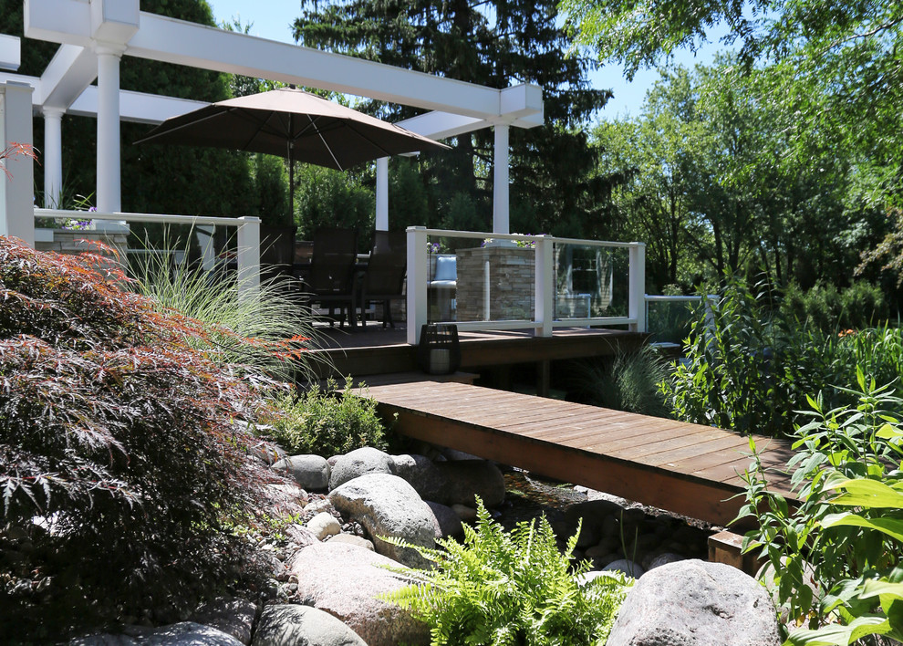 Design ideas for an expansive transitional backyard deck in Chicago with an outdoor kitchen and a pergola.