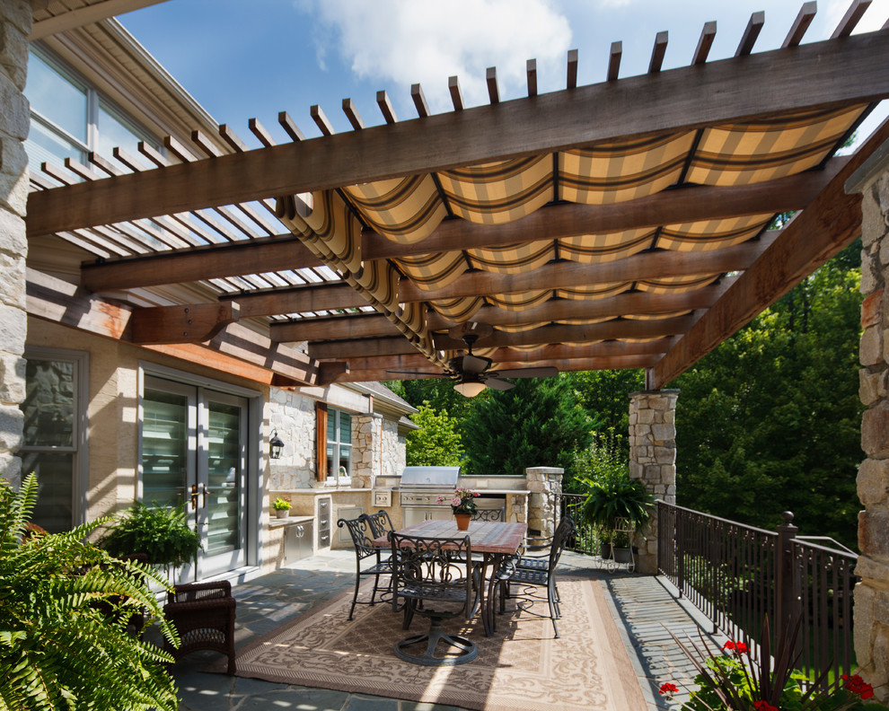Inspiration for a mid-sized transitional backyard patio in Philadelphia with an outdoor kitchen and a pergola.
