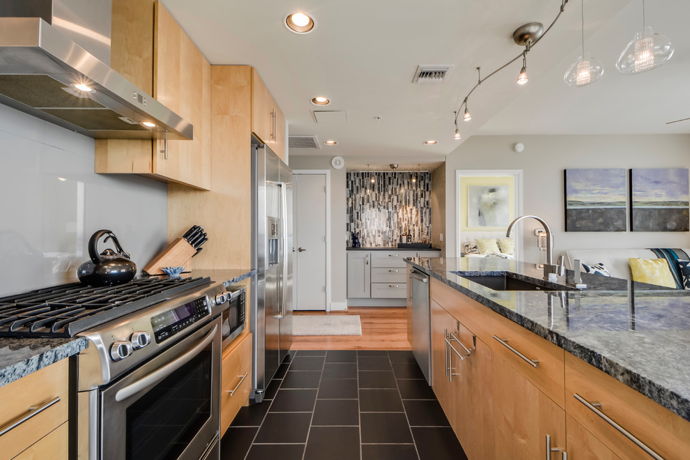 Example of a small transitional galley light wood floor open concept kitchen design in Austin with a double-bowl sink, flat-panel cabinets, light wood cabinets, granite countertops, gray backsplash, porcelain backsplash, stainless steel appliances and an island