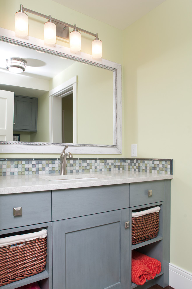 This is an example of a mid-sized beach style bathroom in Grand Rapids with recessed-panel cabinets, grey cabinets, quartzite benchtops, multi-coloured tile, mosaic tile, yellow walls and light hardwood floors.