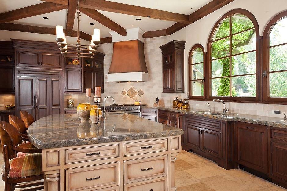 Photo of a mid-sized traditional l-shaped open plan kitchen in Los Angeles with an undermount sink, recessed-panel cabinets, dark wood cabinets, quartz benchtops, beige splashback, porcelain splashback, stainless steel appliances, ceramic floors, with island and beige floor.