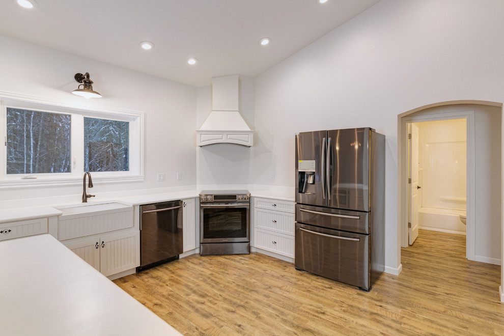 Design ideas for a large transitional u-shaped eat-in kitchen in Other with a farmhouse sink, louvered cabinets, white cabinets, solid surface benchtops, stainless steel appliances, medium hardwood floors and with island.
