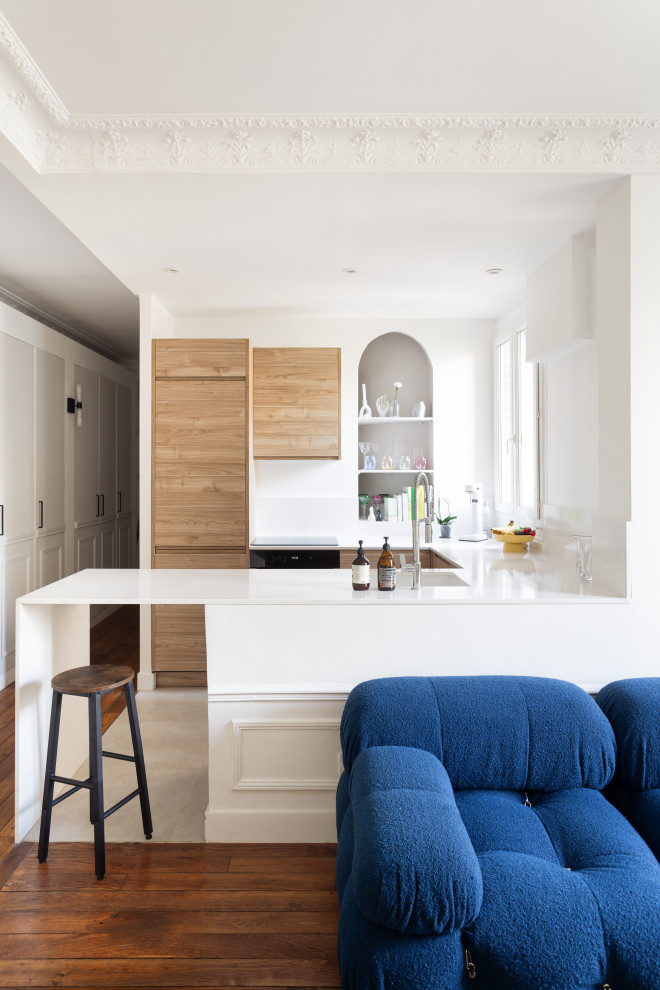 Exempel på ett mellanstort modernt vit vitt kök, med en integrerad diskho, luckor med profilerade fronter, skåp i ljust trä, bänkskiva i kvartsit, vitt stänkskydd, stänkskydd i marmor, svarta vitvaror, en köksö och beiget golv