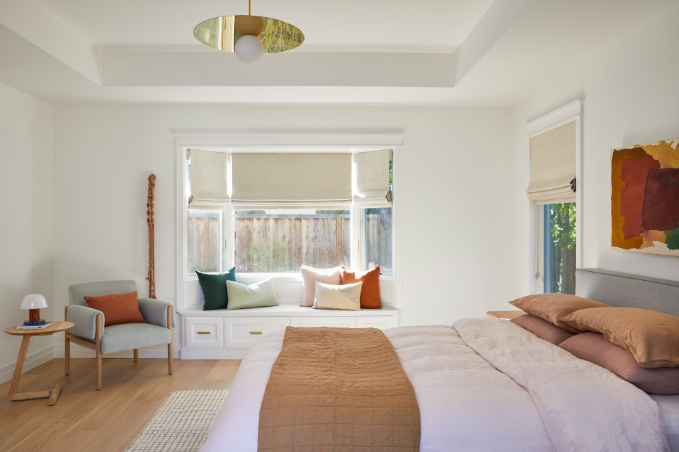 This is an example of a large scandinavian master bedroom in San Francisco with white walls, light hardwood floors, no fireplace, brown floor and coffered.