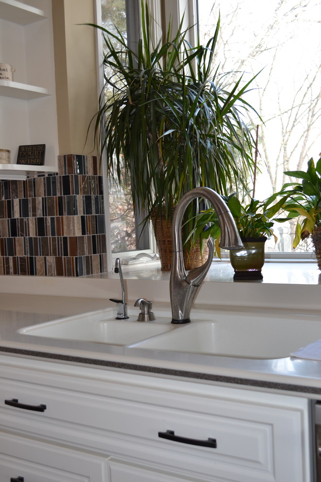 Inspiration for a mid-sized transitional kitchen remodel with an integrated sink, raised-panel cabinets, white cabinets, multicolored backsplash and glass tile backsplash