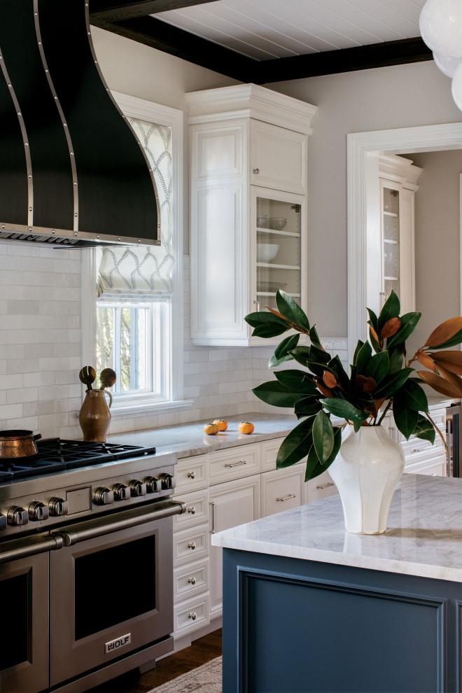 Mid-sized medium tone wood floor, brown floor and exposed beam eat-in kitchen photo in Chicago with recessed-panel cabinets, white cabinets, quartzite countertops, white backsplash, subway tile backsplash, stainless steel appliances, an island and white countertops