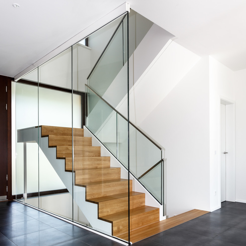 Large contemporary wood u-shaped staircase in Frankfurt with wood risers.