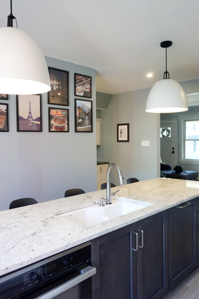 Eat-in kitchen - huge transitional light wood floor and brown floor eat-in kitchen idea with an undermount sink, shaker cabinets, white cabinets, granite countertops, white backsplash, ceramic backsplash, stainless steel appliances, an island and white countertops