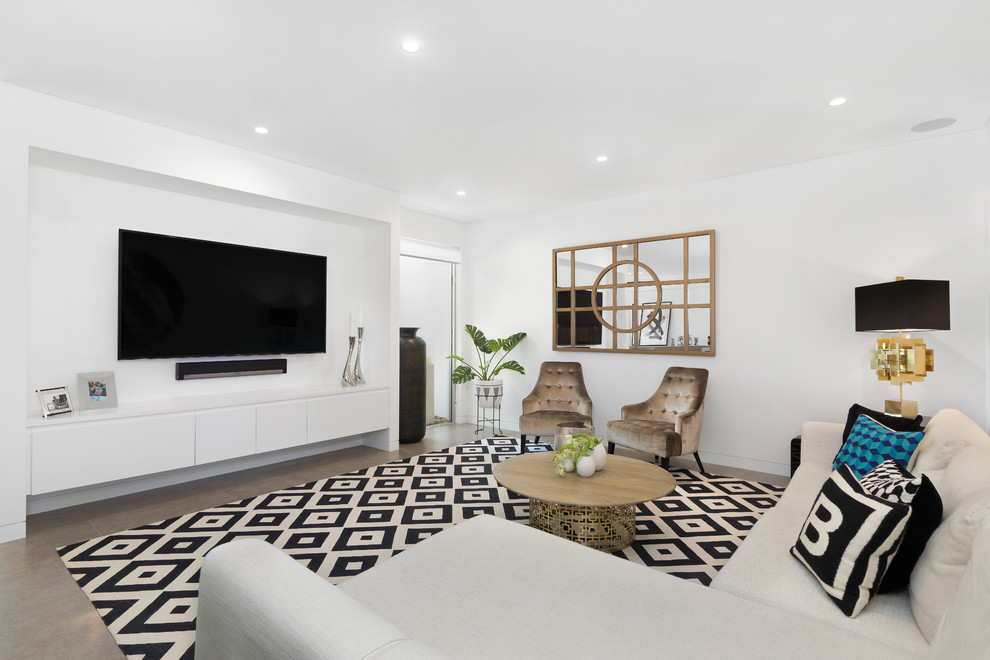 Photo of a contemporary family room in Sydney with white walls, a wall-mounted tv and grey floor.
