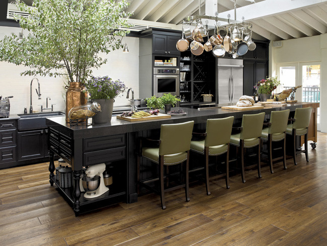 Example of a large transitional single-wall medium tone wood floor open concept kitchen design in Denver with a farmhouse sink, furniture-like cabinets, white cabinets, quartz countertops, white backsplash, stainless steel appliances, white walls and an island