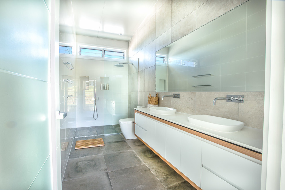 Photo of a mid-sized contemporary master bathroom in Gold Coast - Tweed with an open shower, a one-piece toilet, gray tile, ceramic tile, white walls, mosaic tile floors, a wall-mount sink and marble benchtops.