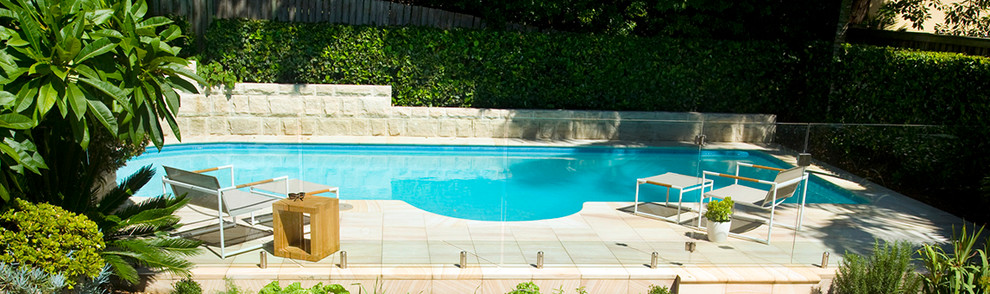 Design ideas for a mid-sized contemporary backyard rectangular pool in Sydney with natural stone pavers.