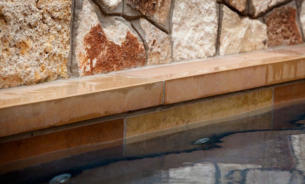 Example of a small classic backyard stone and rectangular lap hot tub design in Austin
