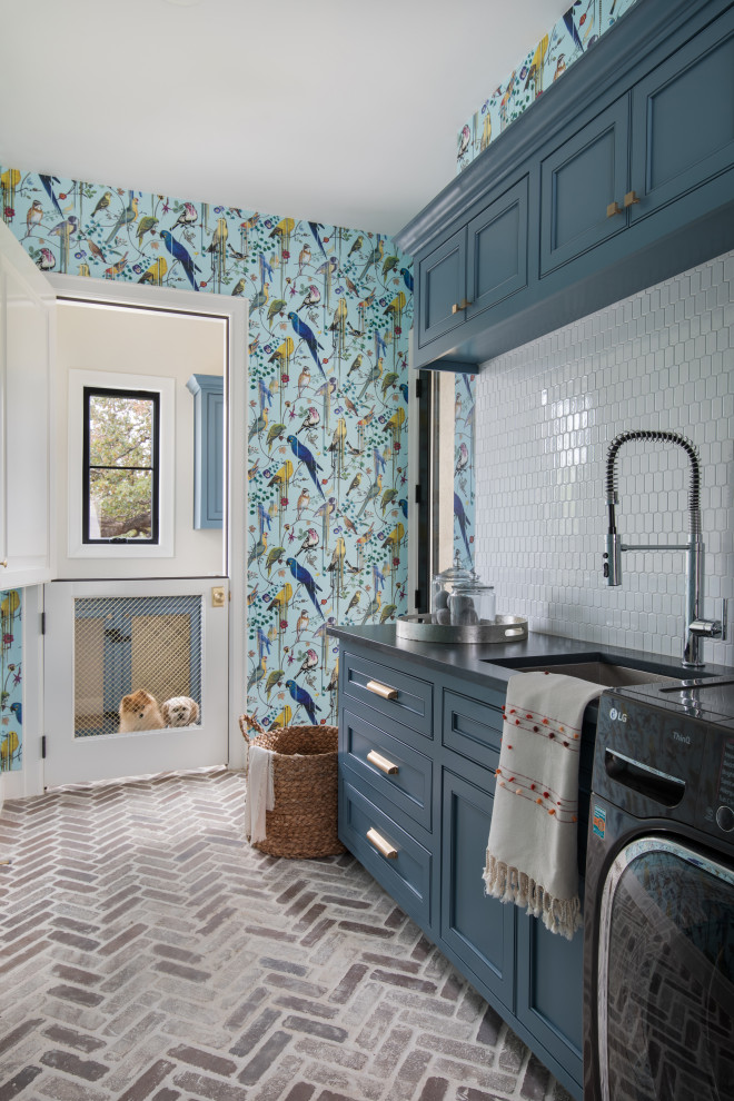 Transitional single-wall brick floor, red floor and wallpaper laundry room photo in Austin with an undermount sink, beaded inset cabinets, blue cabinets, white backsplash, mosaic tile backsplash, multicolored walls, a side-by-side washer/dryer and gray countertops