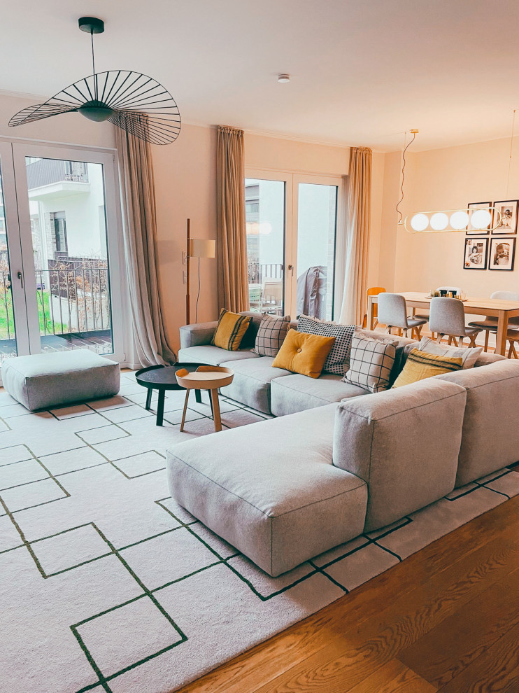 This is an example of a large contemporary living room in Frankfurt with wallpapered walls.