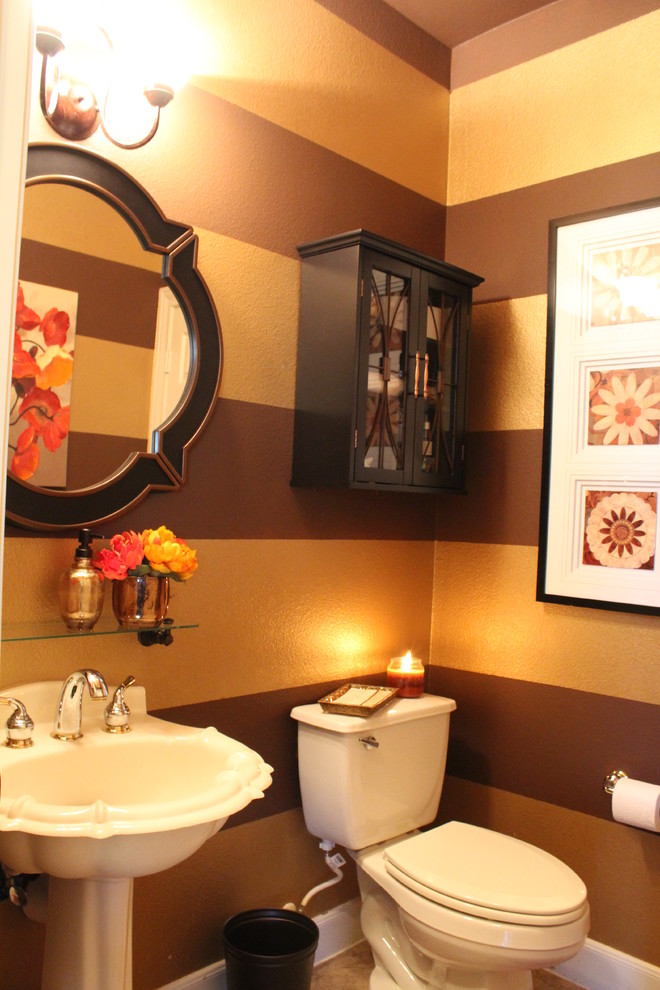Photo of a small transitional powder room in Houston with a pedestal sink, dark wood cabinets, a two-piece toilet, beige tile and brown walls.