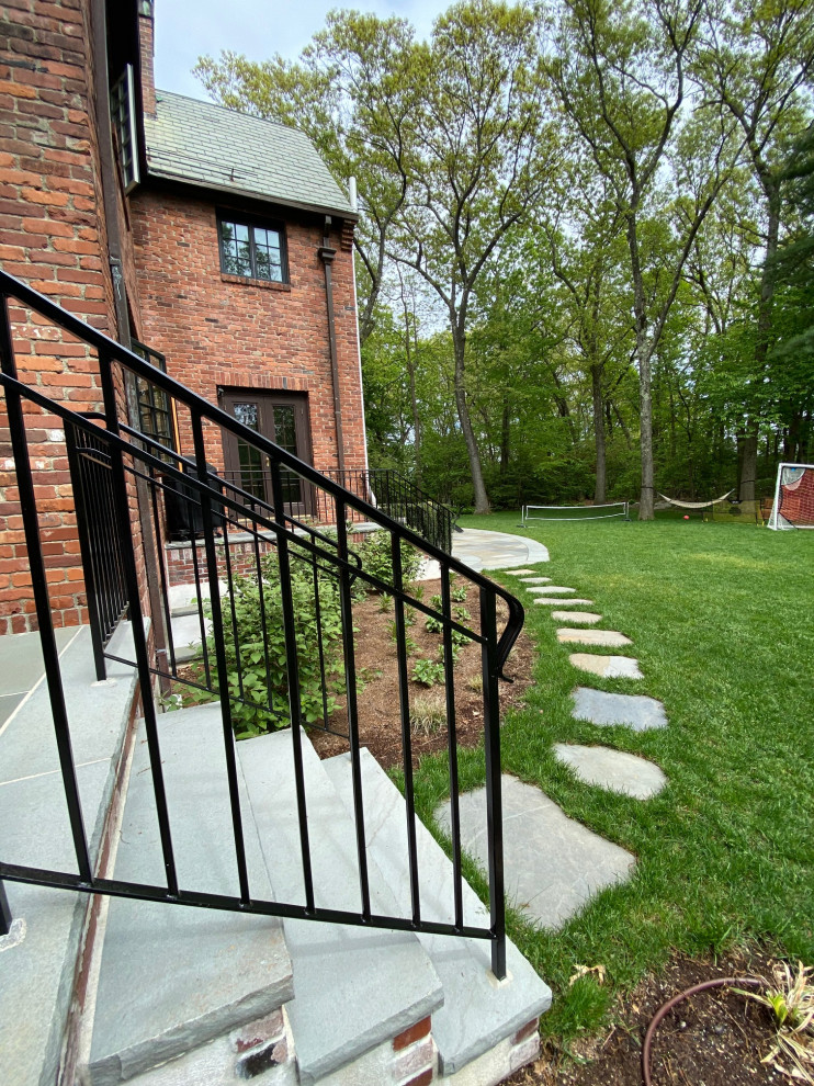 Idee per un portico classico di medie dimensioni e dietro casa con pavimentazioni in pietra naturale e parapetto in metallo