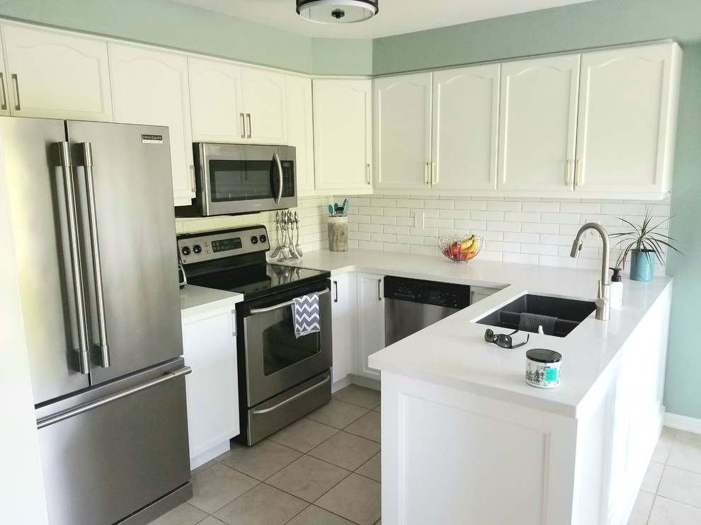 Inspiration for a small transitional u-shaped porcelain tile and beige floor eat-in kitchen remodel in Toronto with a double-bowl sink, recessed-panel cabinets, white cabinets, quartz countertops, white backsplash, subway tile backsplash, stainless steel appliances, a peninsula and white countertops