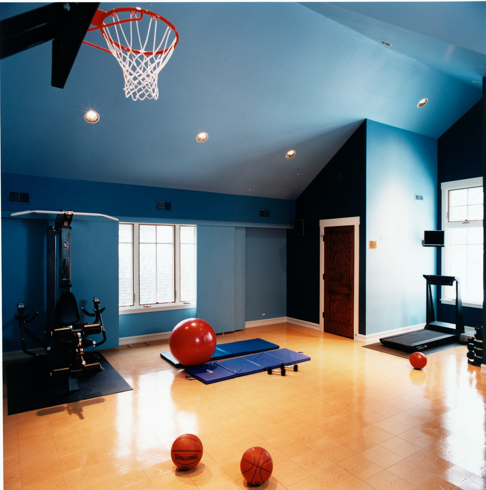 This is an example of a large traditional multipurpose gym in Chicago with blue walls and light hardwood floors.