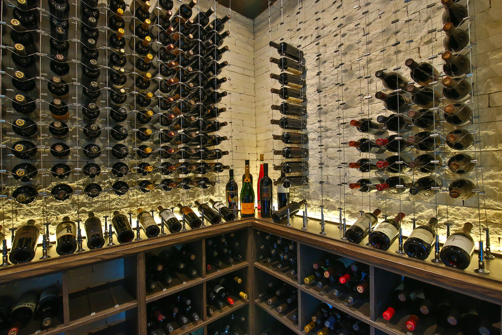 Large contemporary wine cellar in Dallas with storage racks, carpet and beige floor.