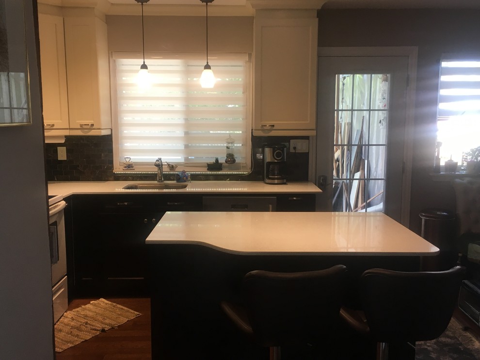 Example of a mid-sized transitional l-shaped enclosed kitchen design in Toronto with an undermount sink, recessed-panel cabinets, dark wood cabinets, quartz countertops, brown backsplash, glass tile backsplash, stainless steel appliances, an island and beige countertops