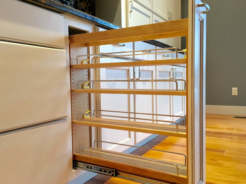 Large transitional l-shaped light wood floor eat-in kitchen photo with an undermount sink, recessed-panel cabinets, white cabinets, granite countertops, multicolored backsplash, glass tile backsplash, stainless steel appliances and an island