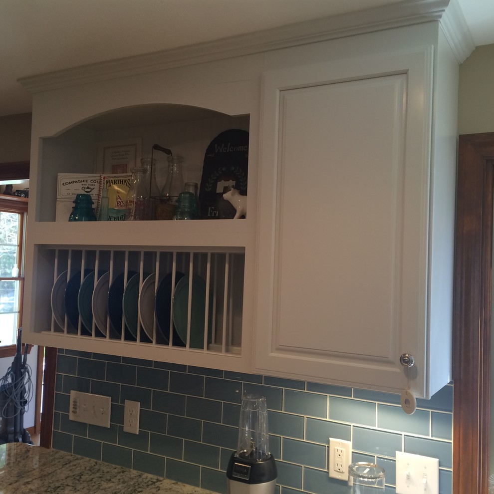 Inspiration for a transitional u-shaped medium tone wood floor eat-in kitchen remodel in Boston with an undermount sink, raised-panel cabinets, white cabinets, granite countertops, blue backsplash, glass tile backsplash, stainless steel appliances and an island