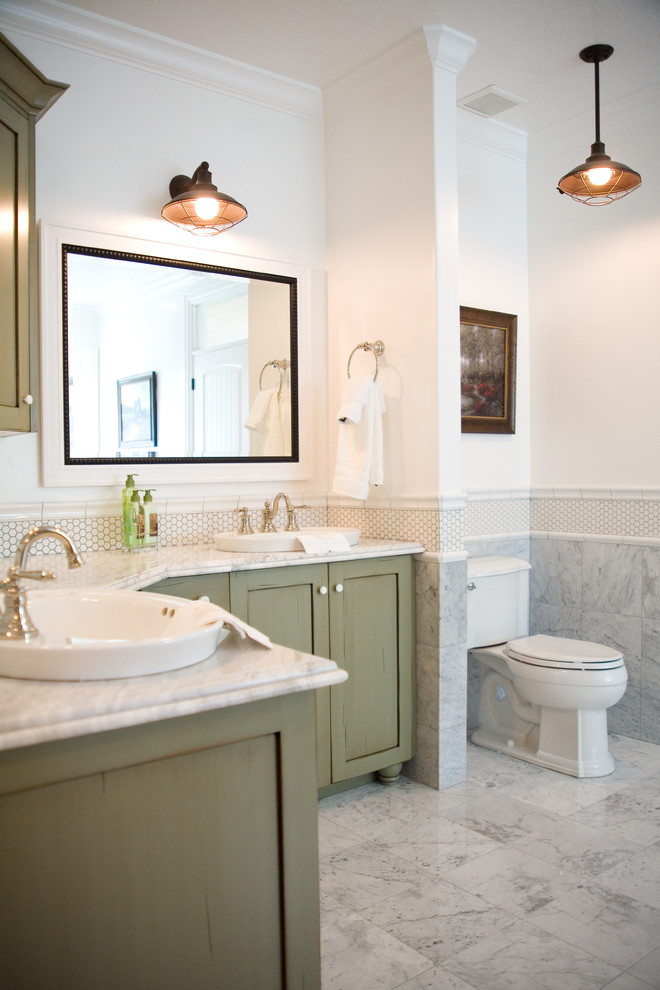 Diseño de cuarto de baño principal de estilo de casa de campo grande con lavabo sobreencimera, armarios con paneles empotrados, puertas de armario verdes, encimera de mármol, bañera esquinera, ducha abierta, sanitario de dos piezas, baldosas y/o azulejos blancos, baldosas y/o azulejos en mosaico, paredes blancas y suelo de mármol