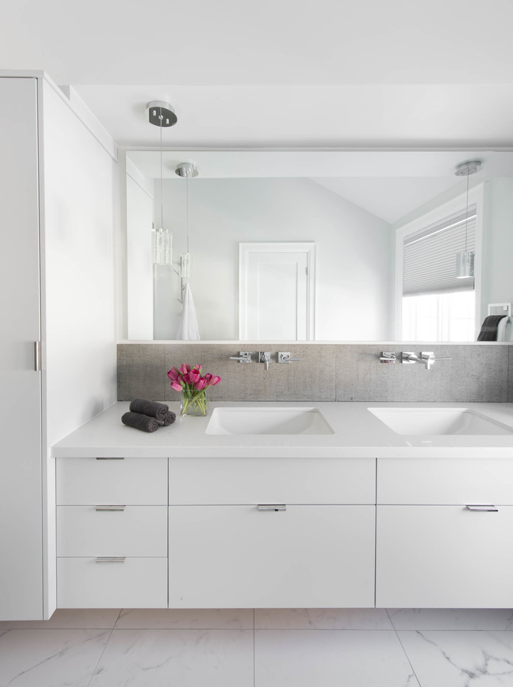 This is an example of a mid-sized modern master bathroom in Toronto with an undermount sink, flat-panel cabinets, white cabinets, quartzite benchtops, an alcove tub, a shower/bathtub combo, porcelain tile, white walls, porcelain floors, gray tile and white benchtops.