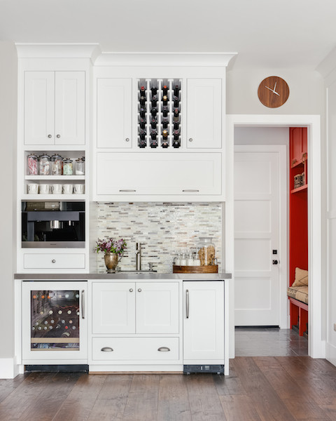 Design ideas for a large country home bar in San Francisco with an undermount sink, beaded inset cabinets, white cabinets, solid surface benchtops, multi-coloured splashback, matchstick tile splashback and dark hardwood floors.