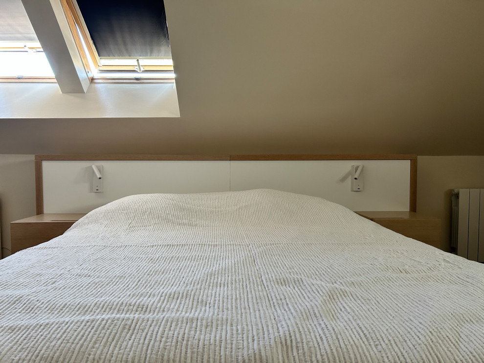Cette image montre une chambre mansardée ou avec mezzanine blanche et bois minimaliste de taille moyenne avec un mur beige, parquet clair, aucune cheminée, un sol marron et dressing.