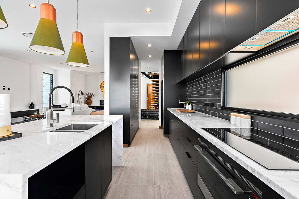 Design ideas for a large contemporary single-wall eat-in kitchen in Brisbane with an undermount sink, flat-panel cabinets, black cabinets, granite benchtops, black splashback, subway tile splashback, stainless steel appliances, porcelain floors, with island and beige floor.