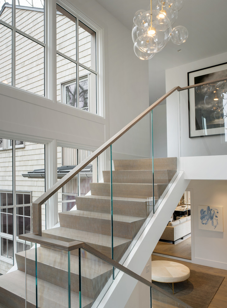 This is an example of a contemporary wood u-shaped staircase in New York with wood risers and glass railing.