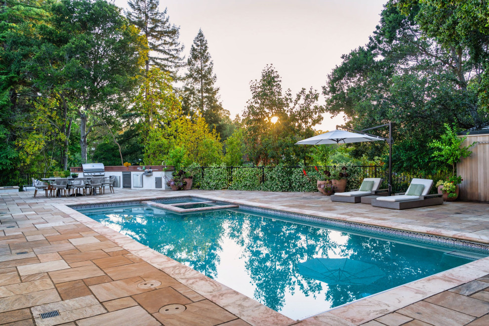 Photo of a large mediterranean backyard pool in San Francisco with natural stone pavers.
