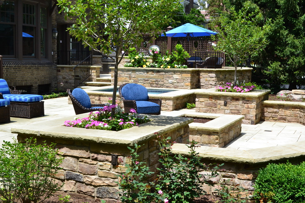 Inspiration for a mid-sized traditional backyard patio in Cleveland with a water feature, natural stone pavers and no cover.