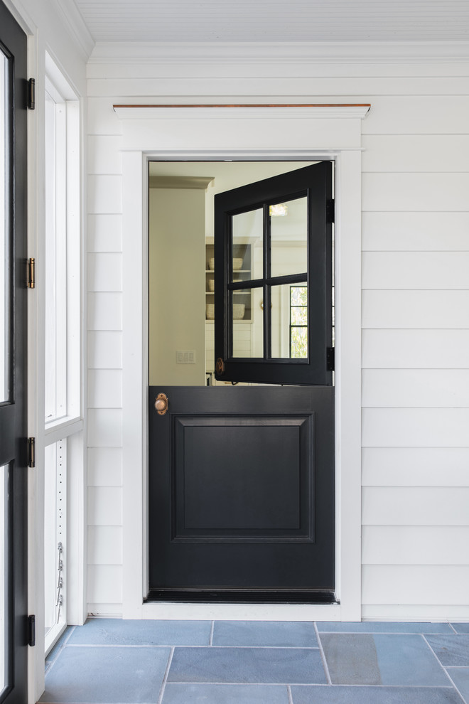This is an example of a small transitional entryway in Grand Rapids with white walls, a dutch front door, a black front door and multi-coloured floor.